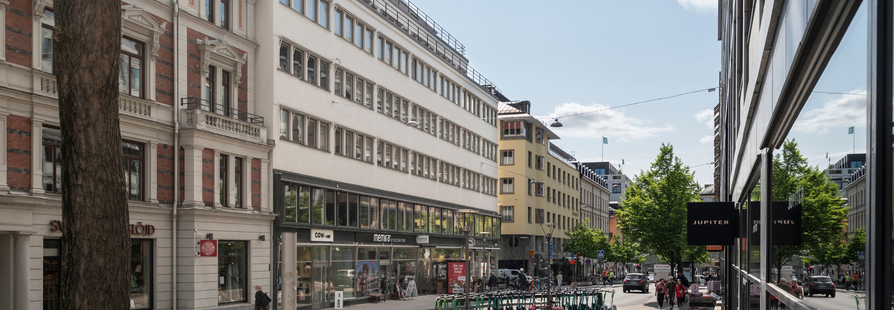 En stadsgata kantad av höga byggnader och parkerade cyklar.