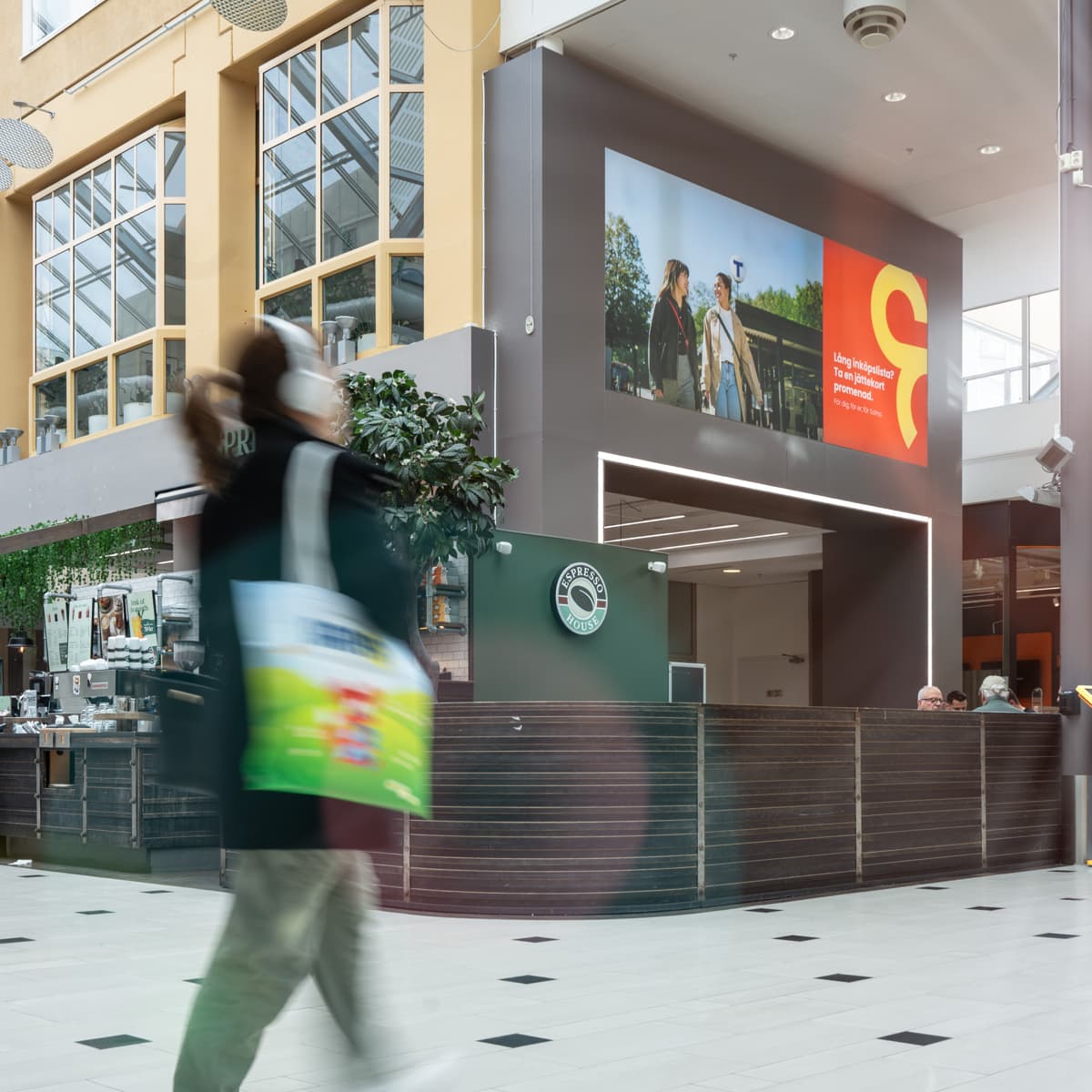 Ett suddigt foto av människor som går i ett köpcentrum.