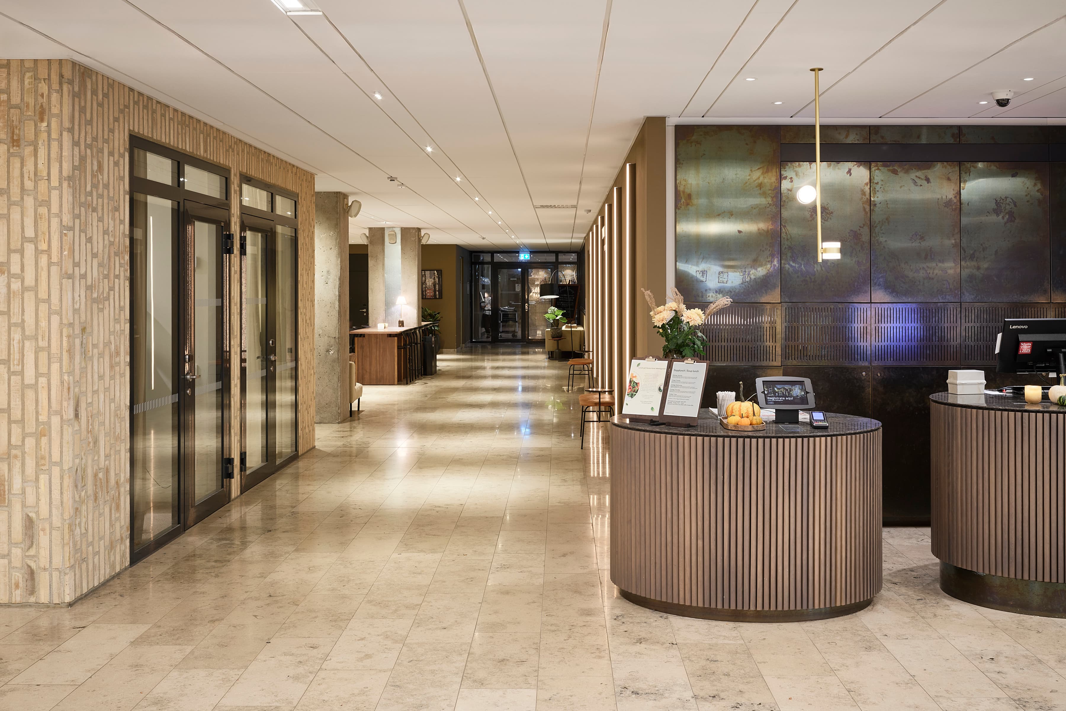 En hotellobby med två runda bord och en telefon på disken.