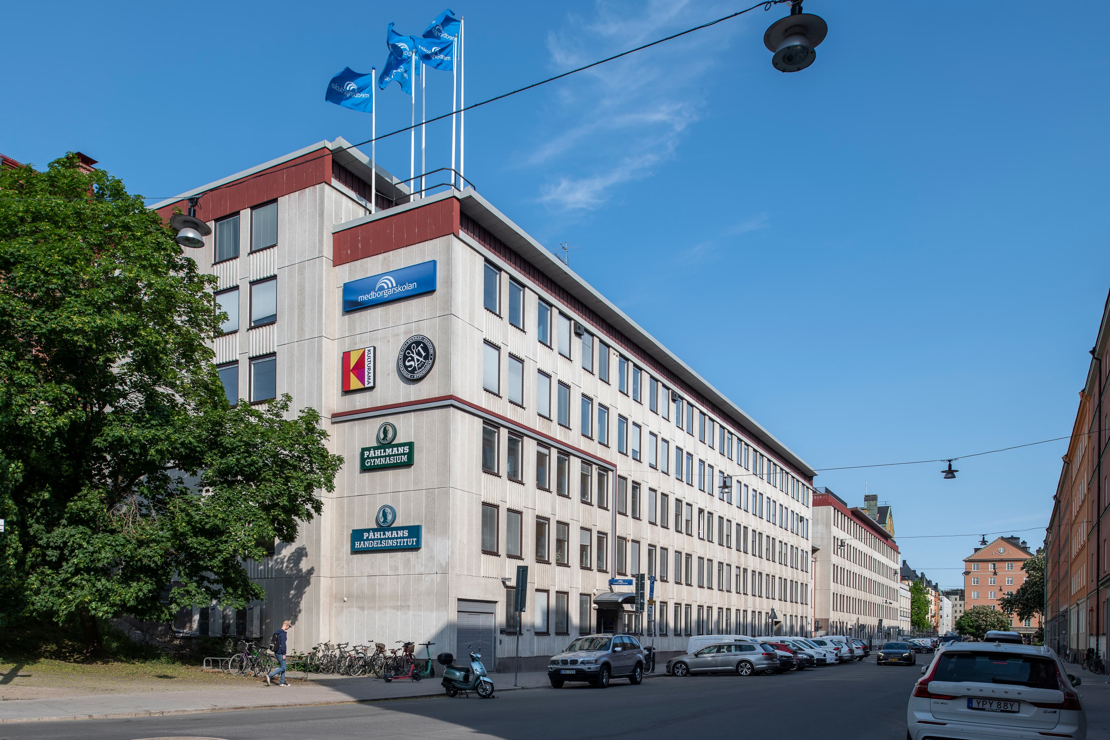 En stor vit byggnad som står vid sidan av en väg.