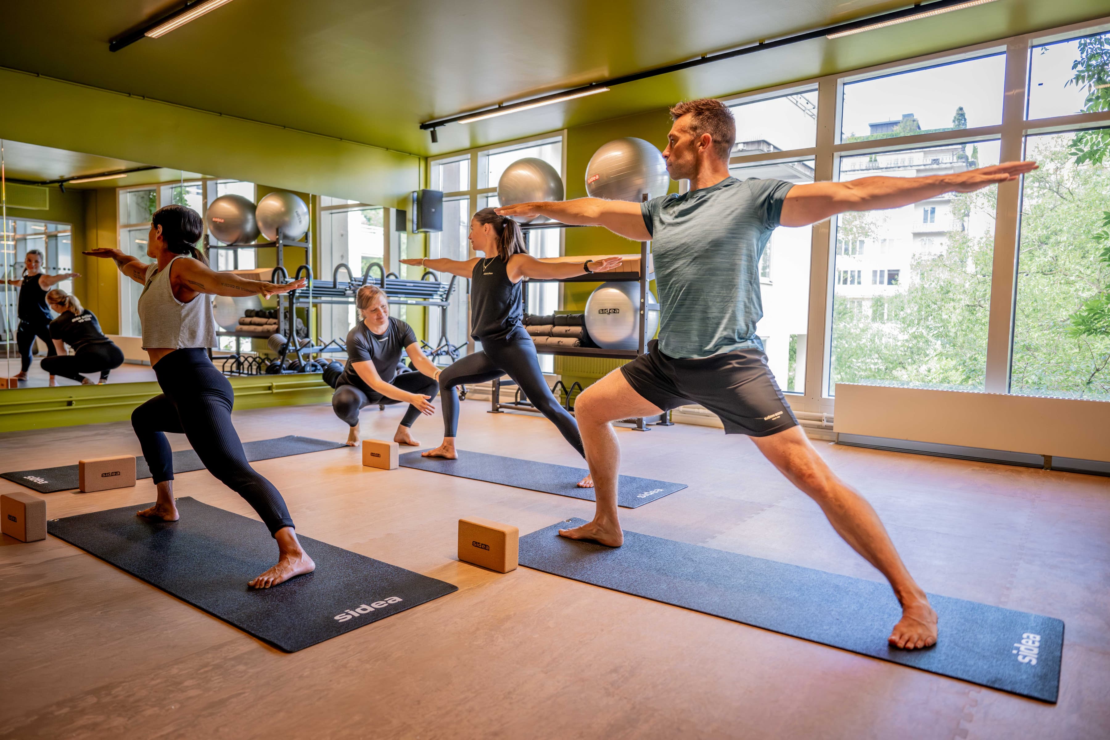 En grupp människor som tränar yoga på ett gym.