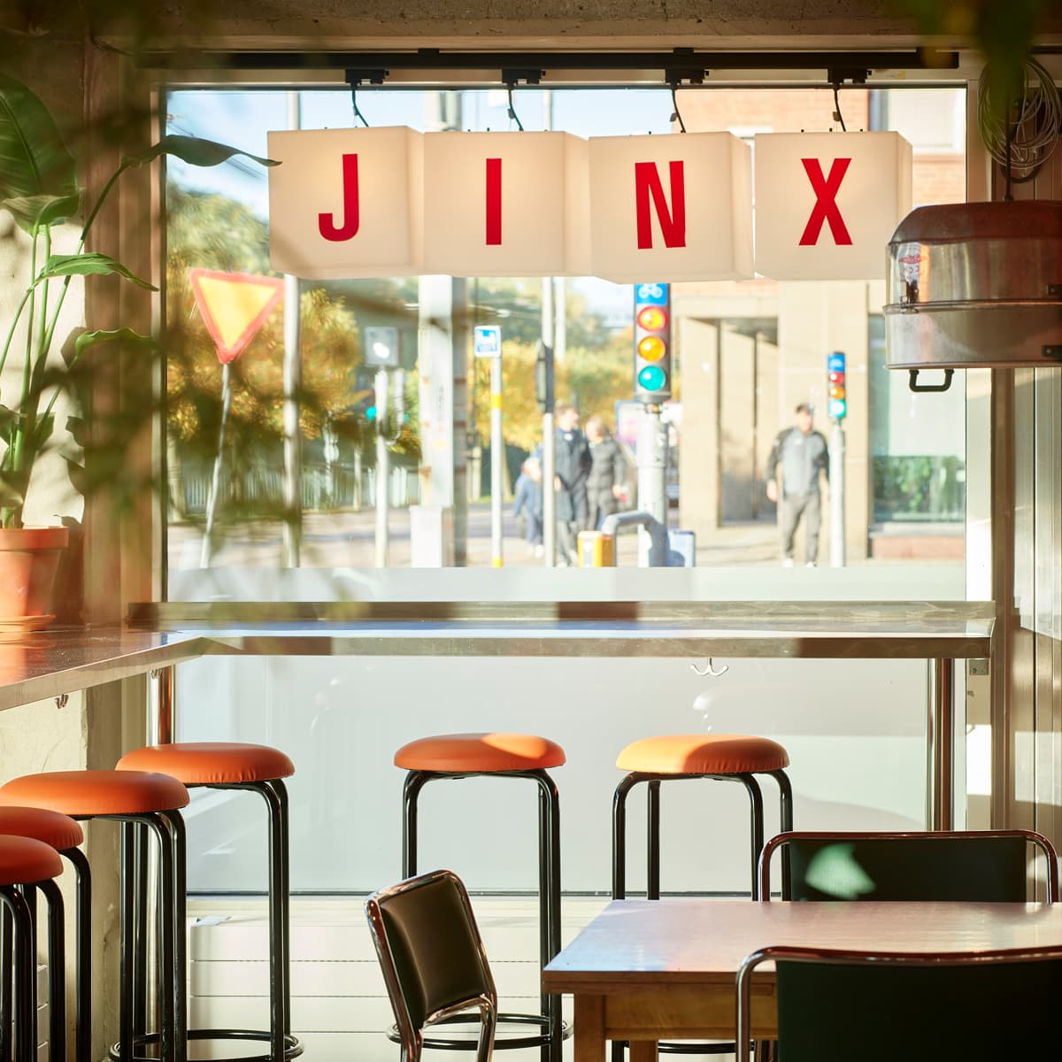 En restaurang med bord och stolar framför ett fönster.