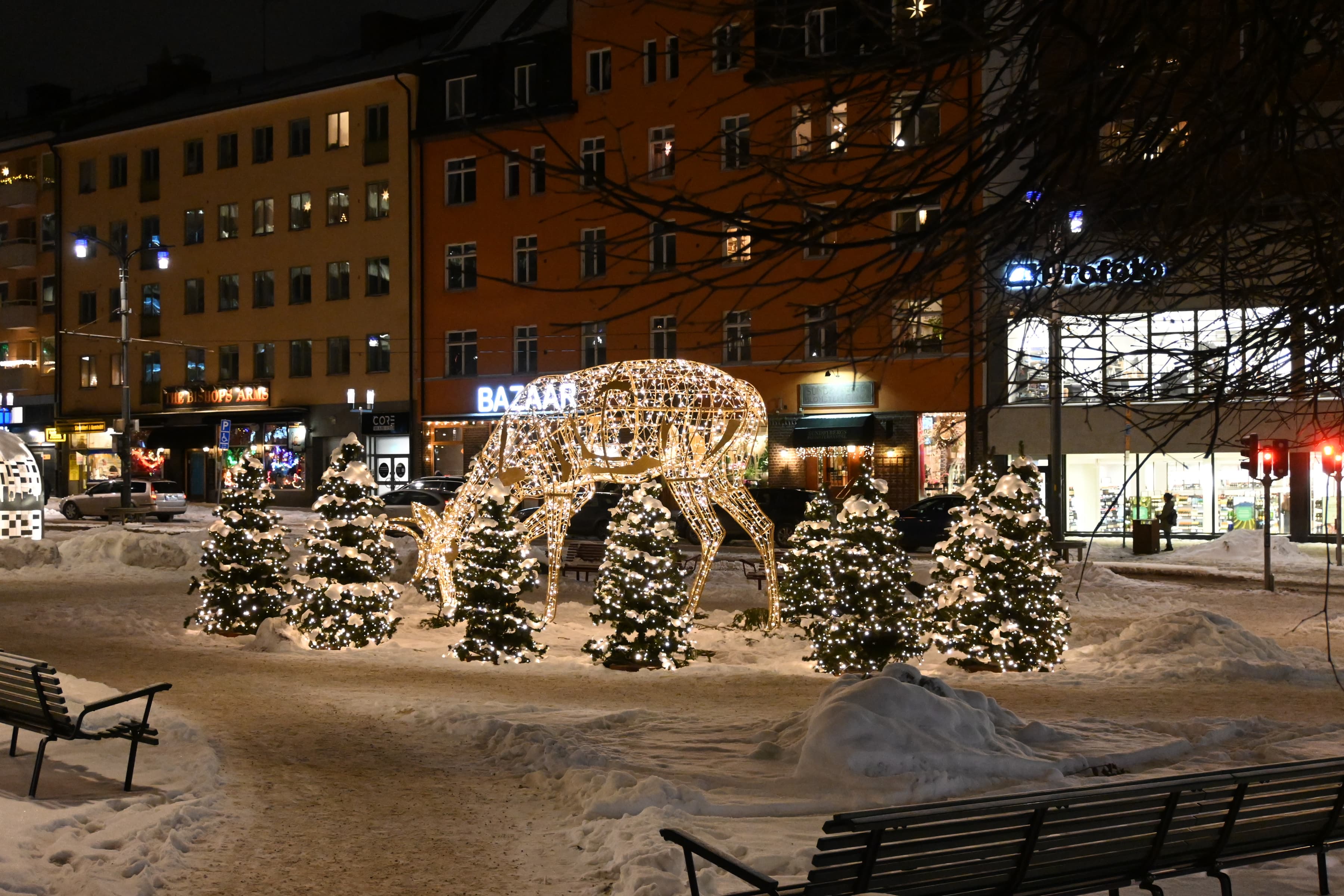 En julskyltning på ett torg i en stad på natten.