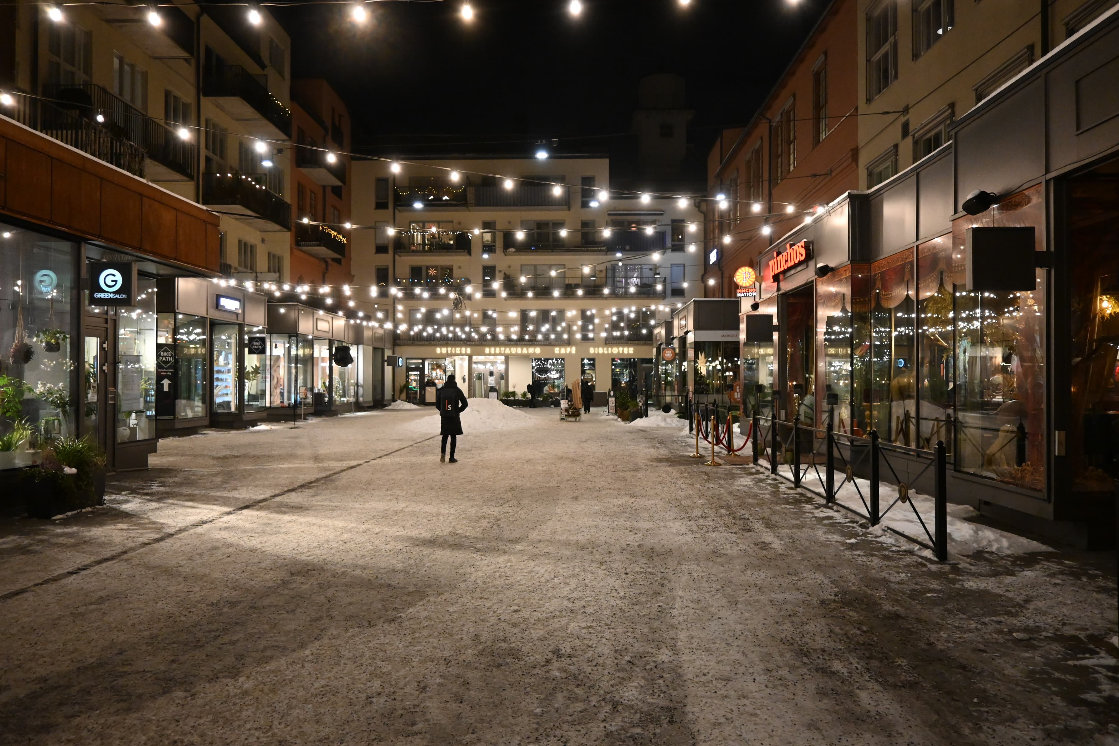 En person som går längs en gata på natten.