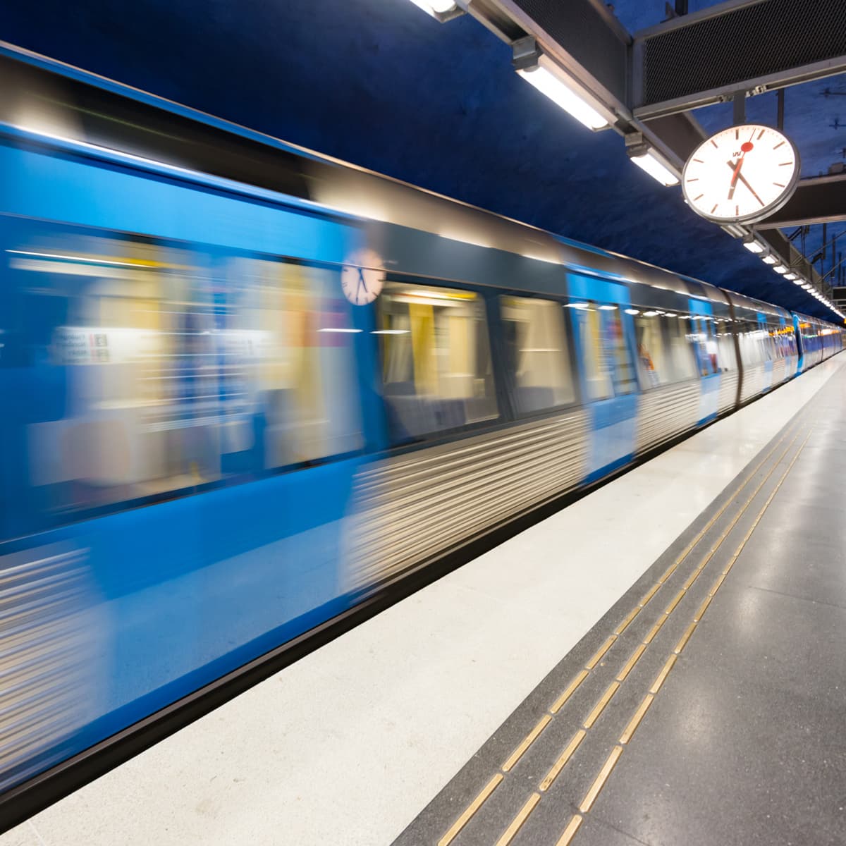 Ett suddigt foto av ett tåg som passerar förbi en plattform.