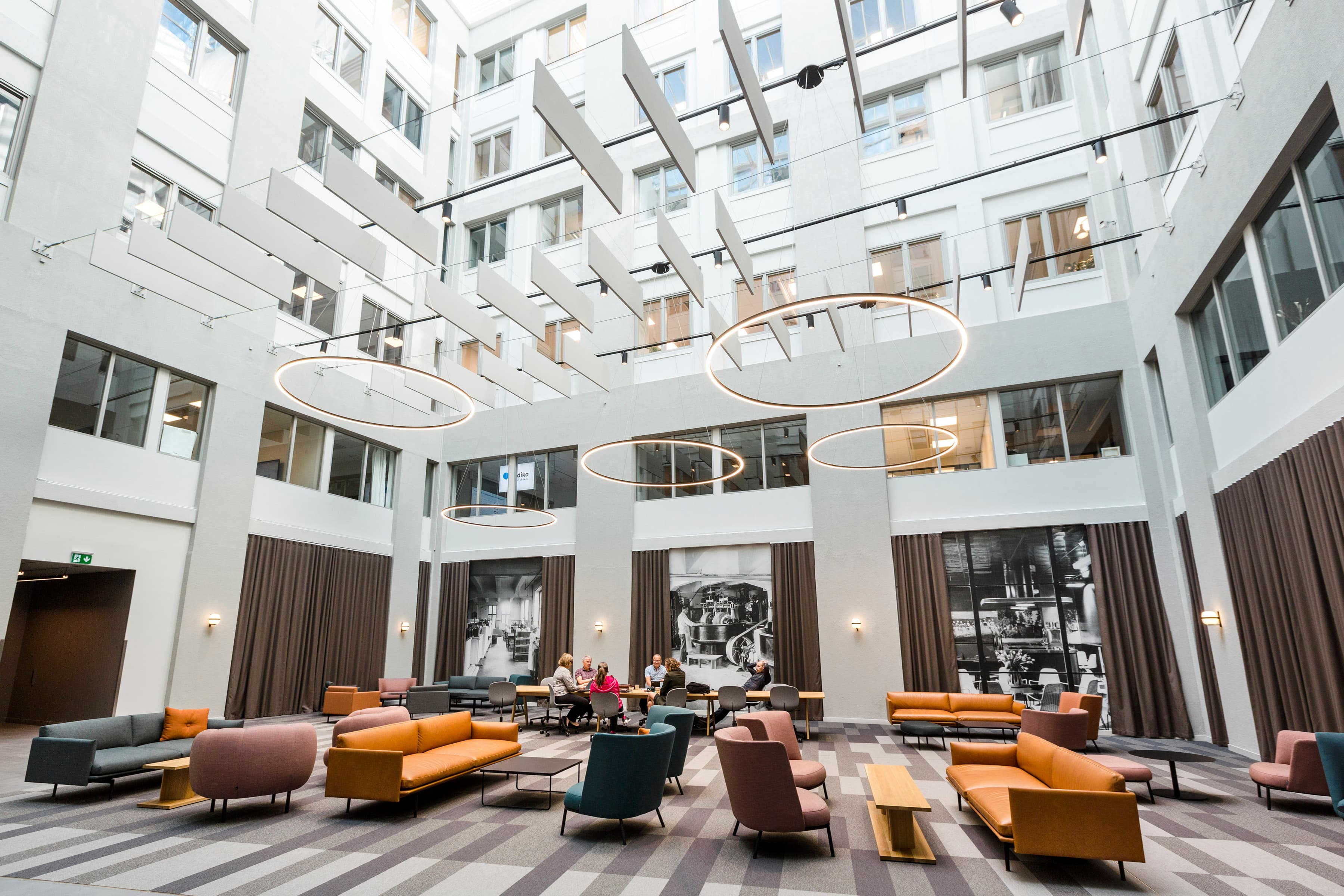 En stor lobby med soffor, stolar och en kristallkrona.